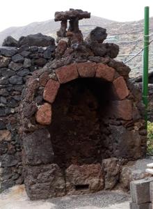 a brick oven with a teddy bear on top of it at Pozo de las Calcosas - El Hierro in Pozo de las Calcosas