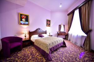 um quarto de hotel com uma cama e uma cadeira em METROPOL HOTEL Yerevan em Yerevan