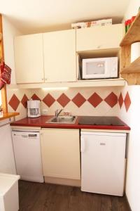 a small kitchen with a sink and a microwave at Appartement Alpe d'huez in LʼHuez