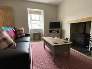a living room with a couch and a coffee table at Islas Cottage, a home in the Heart of Speyside in Dufftown