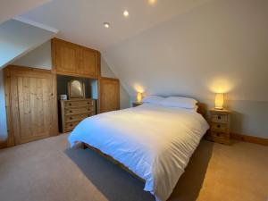 1 dormitorio con 1 cama grande y 2 mesitas de noche en Islas Cottage, a home in the Heart of Speyside, en Dufftown