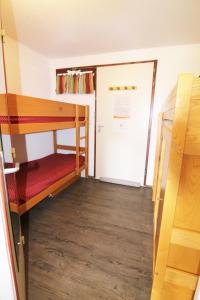 LʼHuezにあるAppartement Alpe d'huezの二段ベッド1組とクローゼットが備わる客室です。