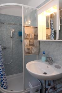 La salle de bains est pourvue d'un lavabo et d'une douche. dans l'établissement Spacious Piran Central Apartment for 5 Pax BG, à Piran