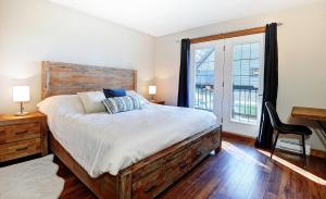 Un dormitorio con una cama grande y una ventana en Chalets Alpins- 5 Chemin des Montagnards, en Stoneham