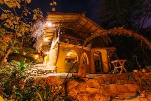 a house with a thatched roof at night at Sol de Minca Eco Lodge in Minca