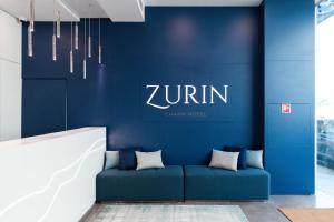里斯本的住宿－Zurin Charm Hotel，大堂的蓝色墙壁和蓝色的沙发