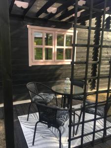 a patio with a table and chairs and a window at 83 Bredynki in Biskupiec