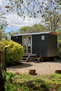 a black tiny house with a table and a wheel at Equestrian Lodge in Holmesfield