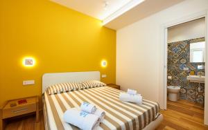 ein Schlafzimmer mit gelben Wänden und einem Bett mit zwei Kissen in der Unterkunft ZEROPENSIERI B&B in Agropoli