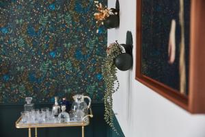 a table with glass items on it next to a painting at Demeure de Manneville - SPA - 1Km des plages de Cabourg in Dives-sur-Mer