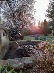 a garden with a water fountain in a yard at Demeure de Manneville - SPA - 1Km des plages de Cabourg in Dives-sur-Mer
