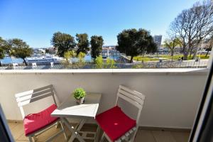 a balcony with two chairs and a table with a plant at Lauris Luxury Apartment Zadar in Zadar