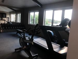 a gym with treadmills and ellipticals in a room with windows at Dela in Hvar