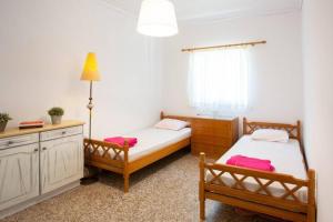 sypialnia z 2 łóżkami, biurkiem i oknem w obiekcie Koko's summer house w mieście Nea Makri
