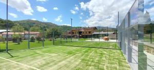 a tennis court with a net on a field at Apartamentos El Castañeu in Corao