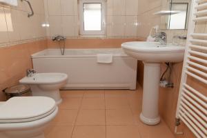 La salle de bains est pourvue d'un lavabo, de toilettes et d'une baignoire. dans l'établissement Hotel Mirni Kutak, à Otočac