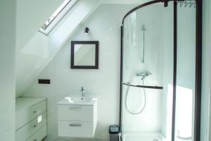 a white bathroom with a shower and a sink at Agroturystyka "Pod Łysicą" in Święta Katarzyna +49 photos