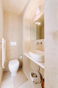 a white bathroom with a sink and a toilet at Dimora Anderì in Polignano a Mare