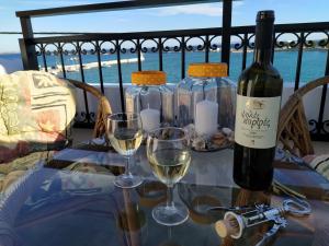 a bottle of wine and two glasses on a table at Aegean Blu Port House Pythagoreio in Pythagoreio