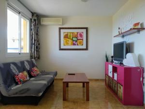 sala de estar con sofá y TV en Casa a 5 min de Cala Blanca [Wi-Fi GARAJE PISCINA], en Alcossebre