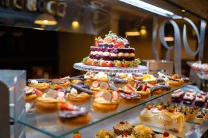 une vitrine avec un gâteau et de nombreuses pâtisseries dans l'établissement Hotel Rouxinol, à Piratuba