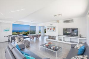 a living room filled with furniture and a large tv at Chloe Luxury Villas in Protaras