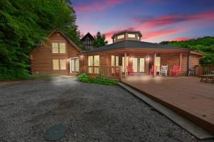 una cabina in legno con una terrazza con sedie rosse di SmokyStays Heated&Private Swim Spa cabin a Gatlinburg