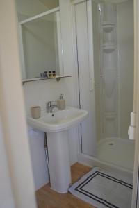 a white bathroom with a sink and a shower at 3SYS in Zakynthos