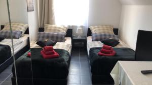 um quarto com dois sofás com almofadas vermelhas em Ferienwohnungen Calwer Höfle Marktplatz - für Firmen, Handwerker und Monteure em Calw