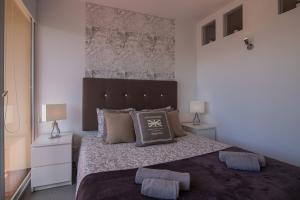1 dormitorio con 1 cama grande, 2 mesitas de noche y 2 lámparas en SUITE ON 7TH VILAMOURA THE BEST VIEW IN TOWN - 1Br, en Quarteira