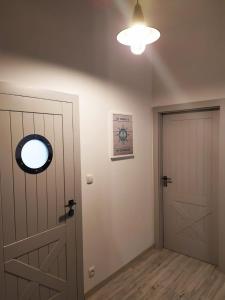 Zimmer mit Tür und Uhr an der Wand in der Unterkunft Aqua Blue Apartament in Reda
