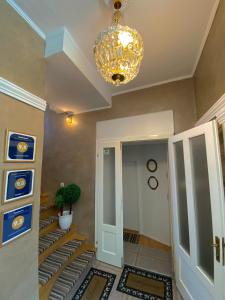 a hallway with a chandelier and a room with stairs at Guesthouse Kod Keme in Sarajevo