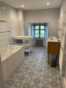 y baño con bañera y lavamanos. en Gîte proche Puy duFou en Mauléon