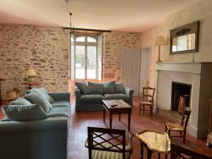 sala de estar con 2 sofás y chimenea en Gîte proche Puy duFou en Mauléon