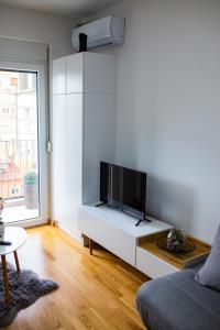 ein Wohnzimmer mit einem Flachbild-TV auf einem weißen Schrank in der Unterkunft RELAX LUX studio in Jagodina