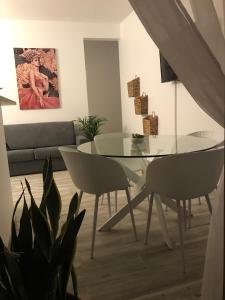 une salle à manger avec une table et des chaises en verre dans l'établissement Bel Appartement lumineux, à Sainte-Luce