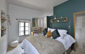 um quarto com uma cama grande e uma parede azul em La Maison de Lourmarin em Lourmarin