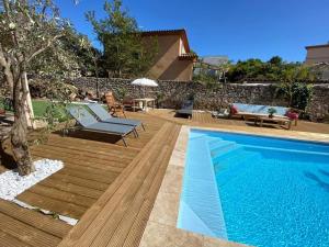 a backyard with a swimming pool and a wooden deck at Gite du stade Grand Studio 2 lits parking in Marseille