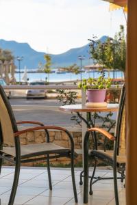 a table with two chairs and a table with a plant on it at Eleni Suites Methoni in Methoni