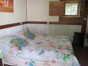a bedroom with a bed with a floral bedspread at Gîte Habas in Habas