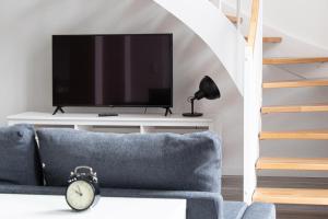 a living room with a tv and a blue couch at Ferienwohnungen Galerie im Klink in Quedlinburg