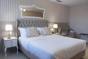 a bedroom with a large white bed and a chair at Bella Gramado in Gramado