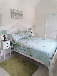 um quarto branco com uma cama e uma mesa de cabeceira com uma cama sidx sidx sidx em Medlyn moor retreats em Porkellis