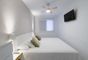 um quarto branco com uma cama e uma ventoinha de tecto em Apartment EL Médano Experimental Beach em El Médano