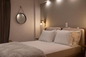 a bedroom with a bed with white pillows and a mirror at Langi Apartments in Missolonghi