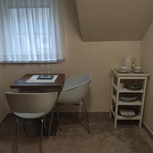 um quarto com uma mesa e duas cadeiras e uma janela em Penzion Hastrman em Banská Bystrica