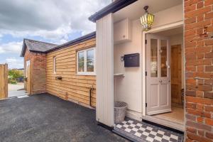 a door to a garage with a brick building at Immaculate luxury retreat in pretty village with great pubs - Box Valley Cottage in Stoke by Nayland