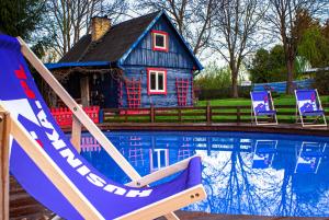 a house and a pool with chairs and a house at Agroturystyka Husinka pl in Husinka