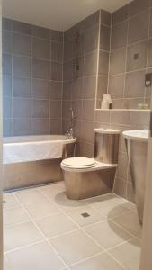 een badkamer met een toilet, een wastafel en een bad bij Sky Night Serviced Apartments in Cardiff