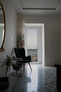 ein Wohnzimmer mit einem Stuhl und einem Fenster in der Unterkunft Le Radici in Castellammare di Stabia
